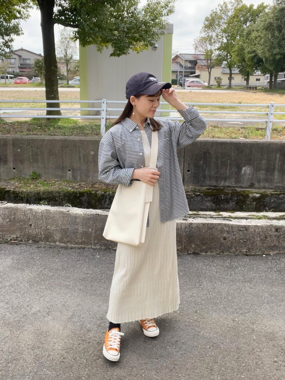 ブラック系のシャツ/ブラウス、ホワイト系のワンピース、ホワイト系のショルダーバッグを着用したレディースの春コーディネートの2枚目の写真