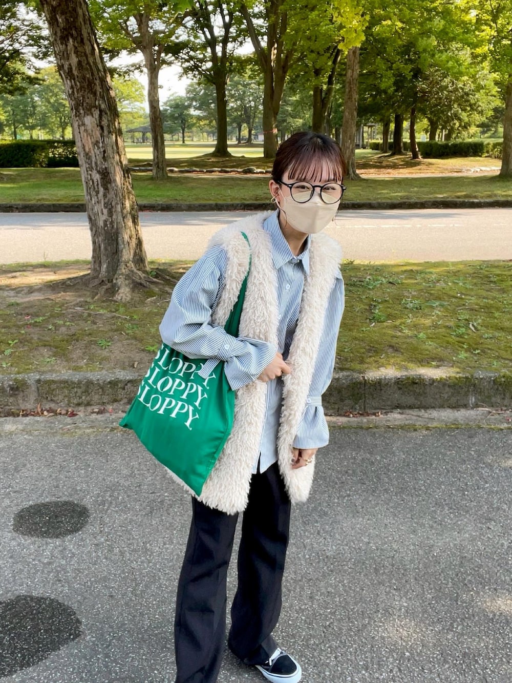 ブラック系のシャツ/ブラウス、ホワイト系のベスト、グリーン系のトートバッグを着用したレディースの秋コーディネートの5枚目の写真