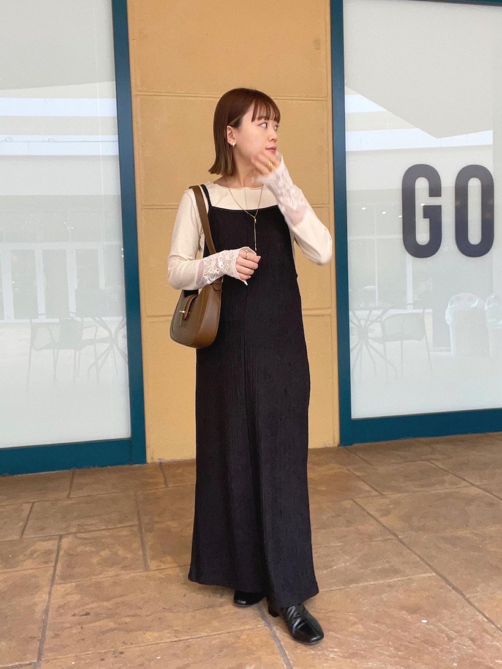 ベージュ系のTシャツ/カットソー、ブラック系のワンピース/ドレス、ブラウン系のバッグを着用したレディースの秋コーディネートの2枚目の写真