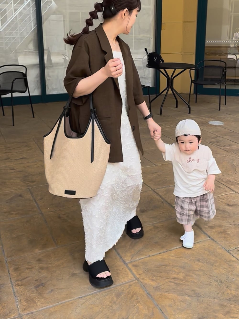 ブラウン系のテーラードジャケット、ブラック系のトートバッグ、ホワイト系のワンピース/ドレスを着用したレディースの夏コーディネートの5枚目の写真