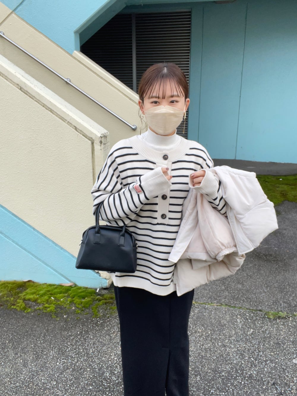 ホワイト系のニット/セーター、ホワイト系のダウンベスト、ブラック系のスカートを着用したレディースの冬コーディネートの4枚目の写真