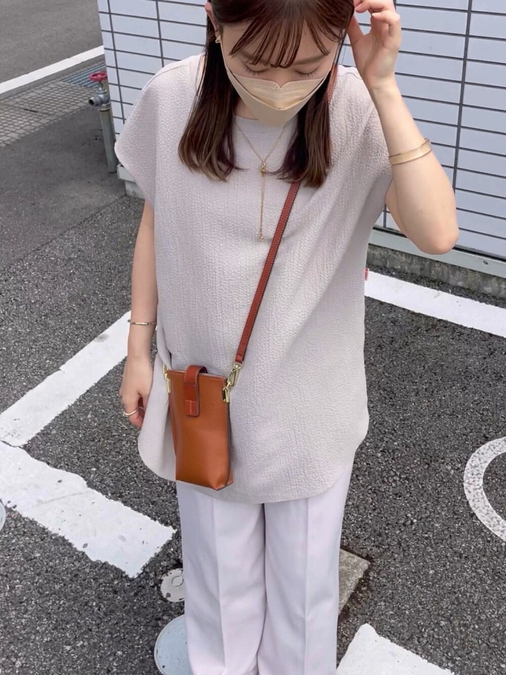 ベージュ系のTシャツ/カットソー、ホワイト系のその他パンツ、ブラウン系のショルダーバッグを着用したレディースの夏コーディネートの4枚目の写真