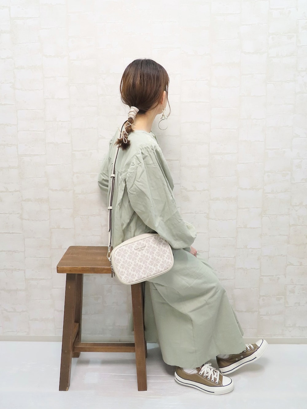 グリーン系のワンピース、ホワイト系のショルダーバッグ、ブラウン系のスニーカーを着用したレディースの春コーディネートの2枚目の写真