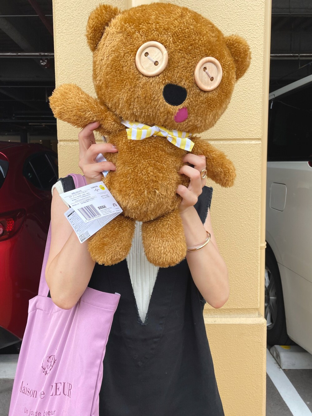 ブラック系のベスト、ホワイト系のワンピース、パープル系のトートバッグを着用したレディースの夏コーディネートの3枚目の写真