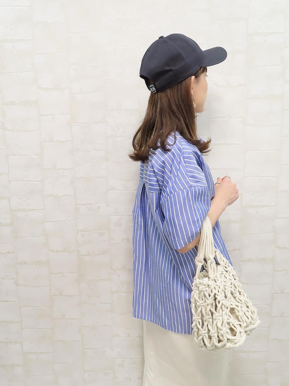 ブルー系のシャツ/ブラウス、ブルー系のTシャツ/カットソー、ホワイト系のジャンパースカートを着用したレディースの夏コーディネートの3枚目の写真