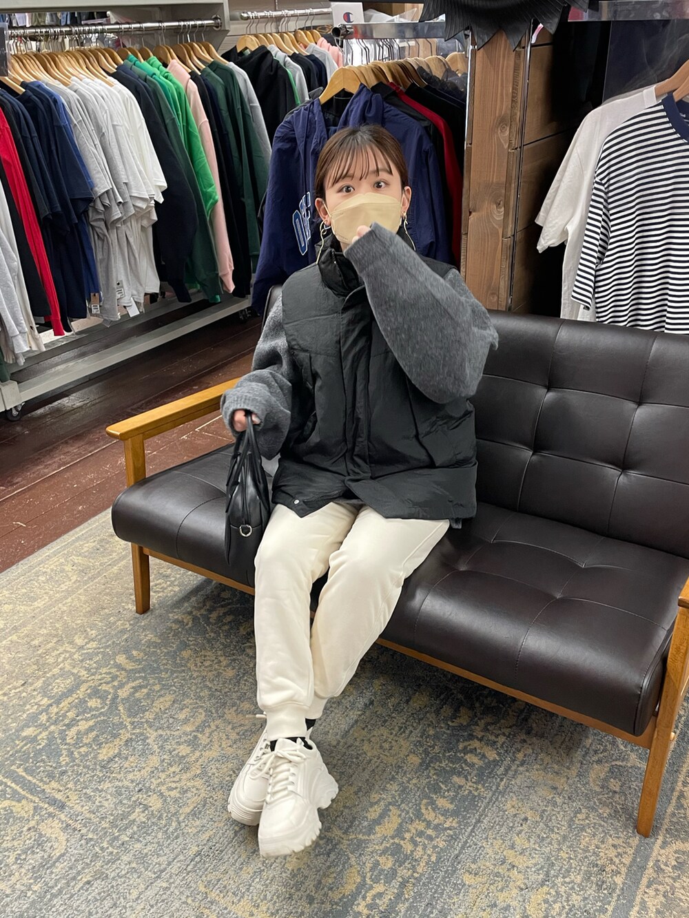 グレー系のニット/セーター、ブラック系のダウンベスト、ホワイト系のパンツを着用したレディースの冬コーディネートの4枚目の写真