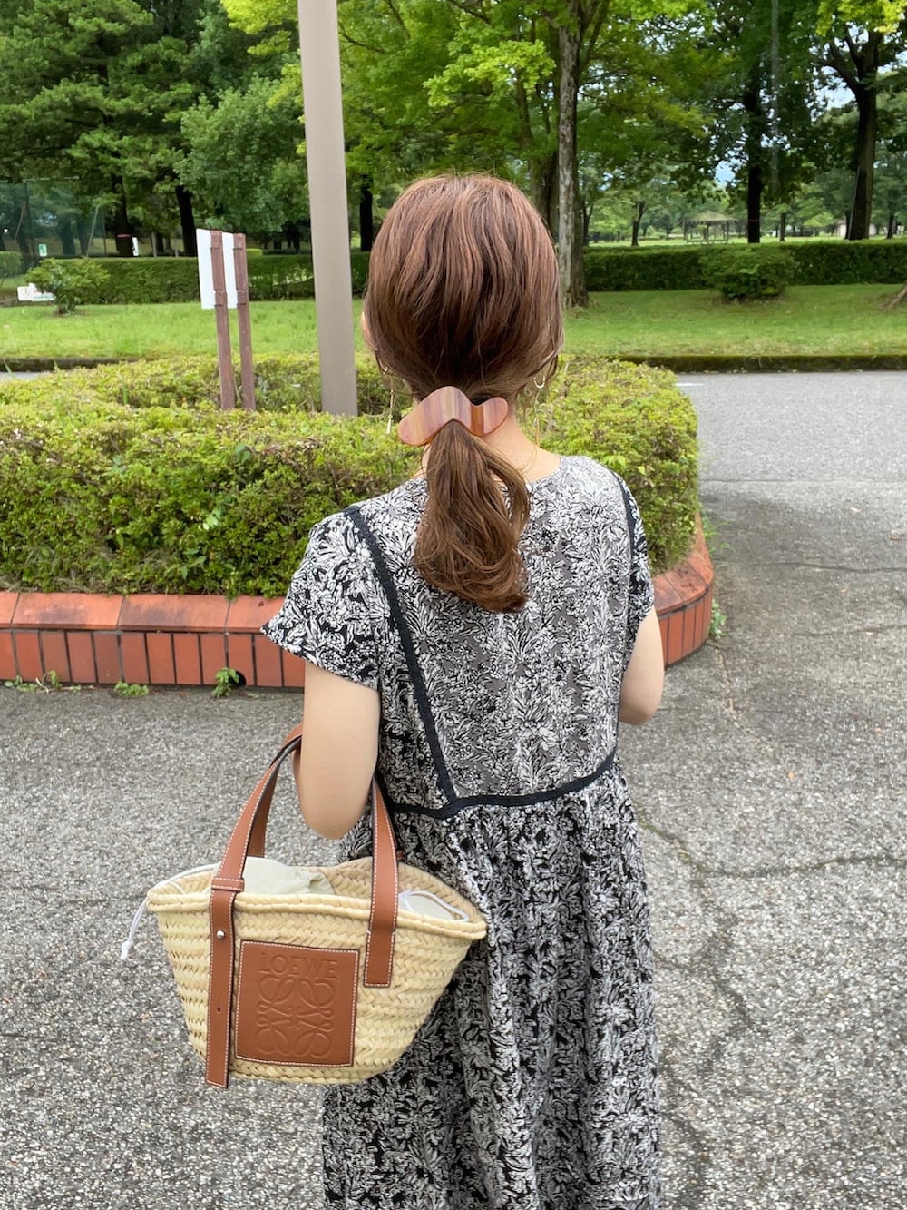 ブラック系のワンピース、ベージュ系のかごバッグ、ブラック系のサンダルを着用したレディースの夏コーディネートの3枚目の写真
