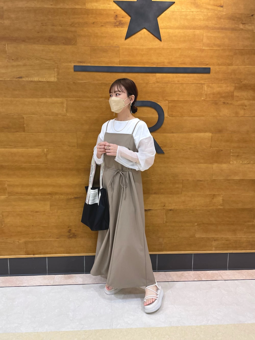 ブラウン系のワンピース、ホワイト系のTシャツ/カットソー、ブラック系のトートバッグを着用したレディースの春コーディネートの4枚目の写真