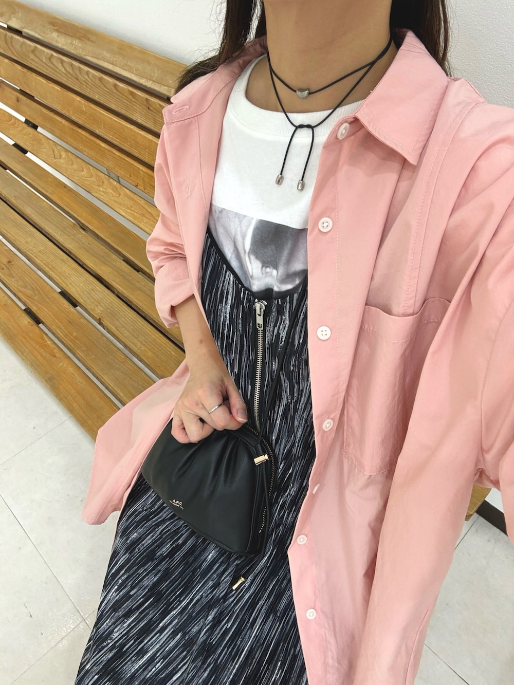 ピンク系のシャツ/ブラウス、ホワイト系のTシャツ/カットソー、ブラック系のワンピースを着用したレディースの秋コーディネートの4枚目の写真