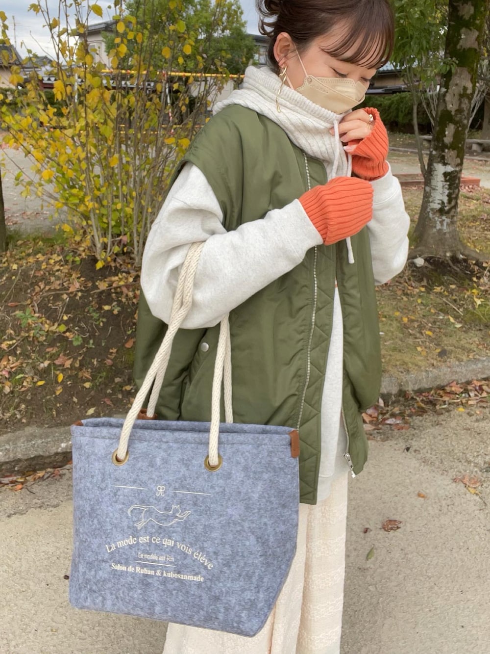 グレー系のトートバッグ、グレー系のスウェット、グリーン系のMA-1を着用したレディースの秋コーディネートの5枚目の写真