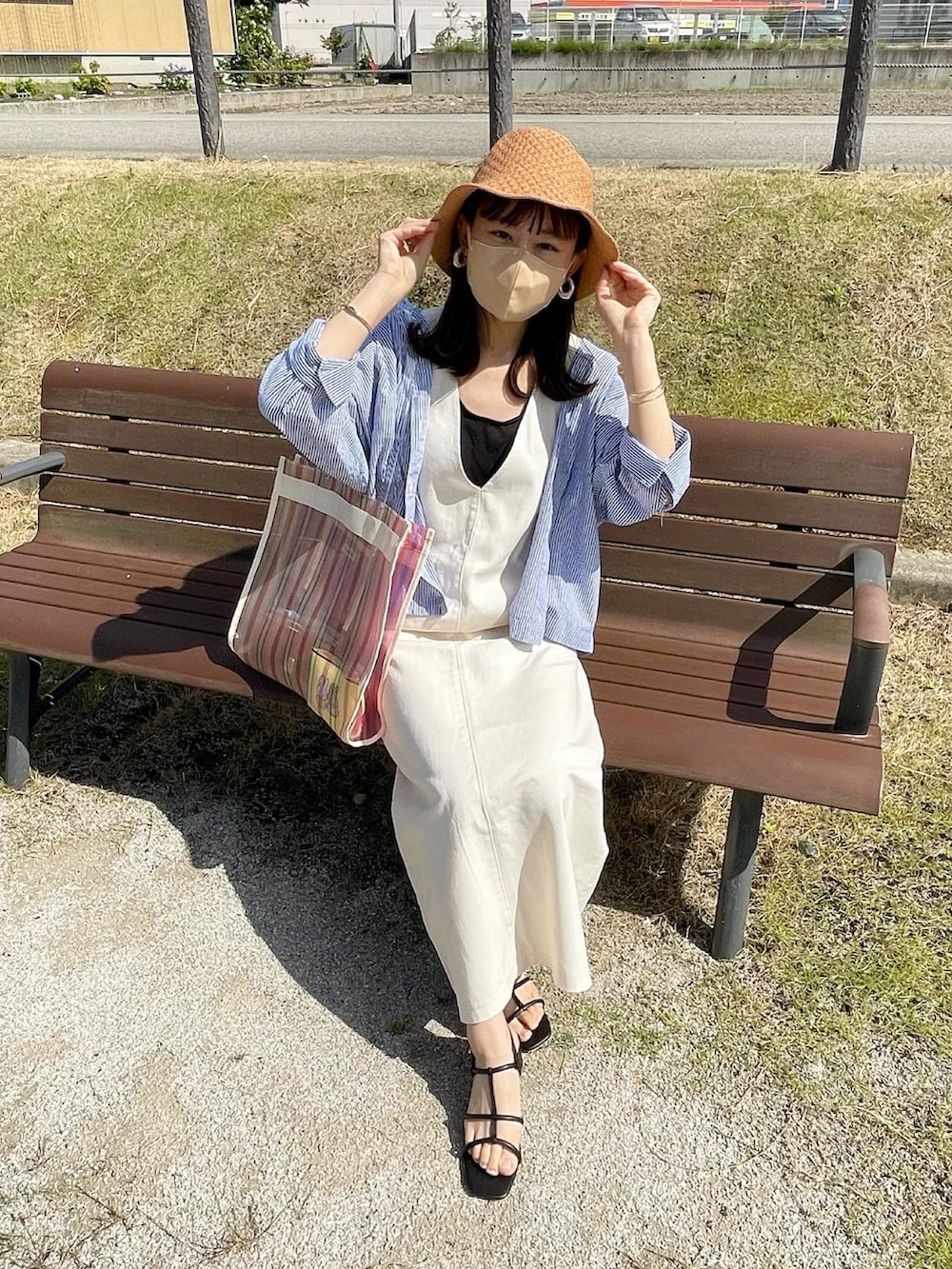 ブルー系のシャツ/ブラウス、ホワイト系のジャンパースカート、ホワイト系のトートバッグを着用したレディースの夏コーディネートの3枚目の写真