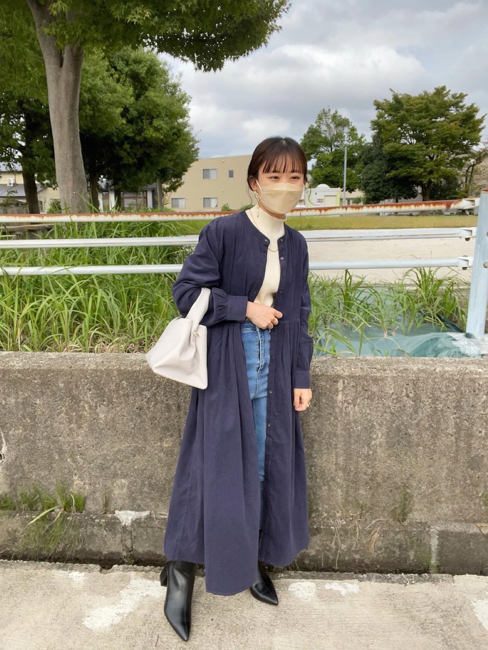 ブルー系のワンピース、ブラック系のブーツ、ホワイト系のニット/セーターを着用したレディースの秋コーディネートの5枚目の写真