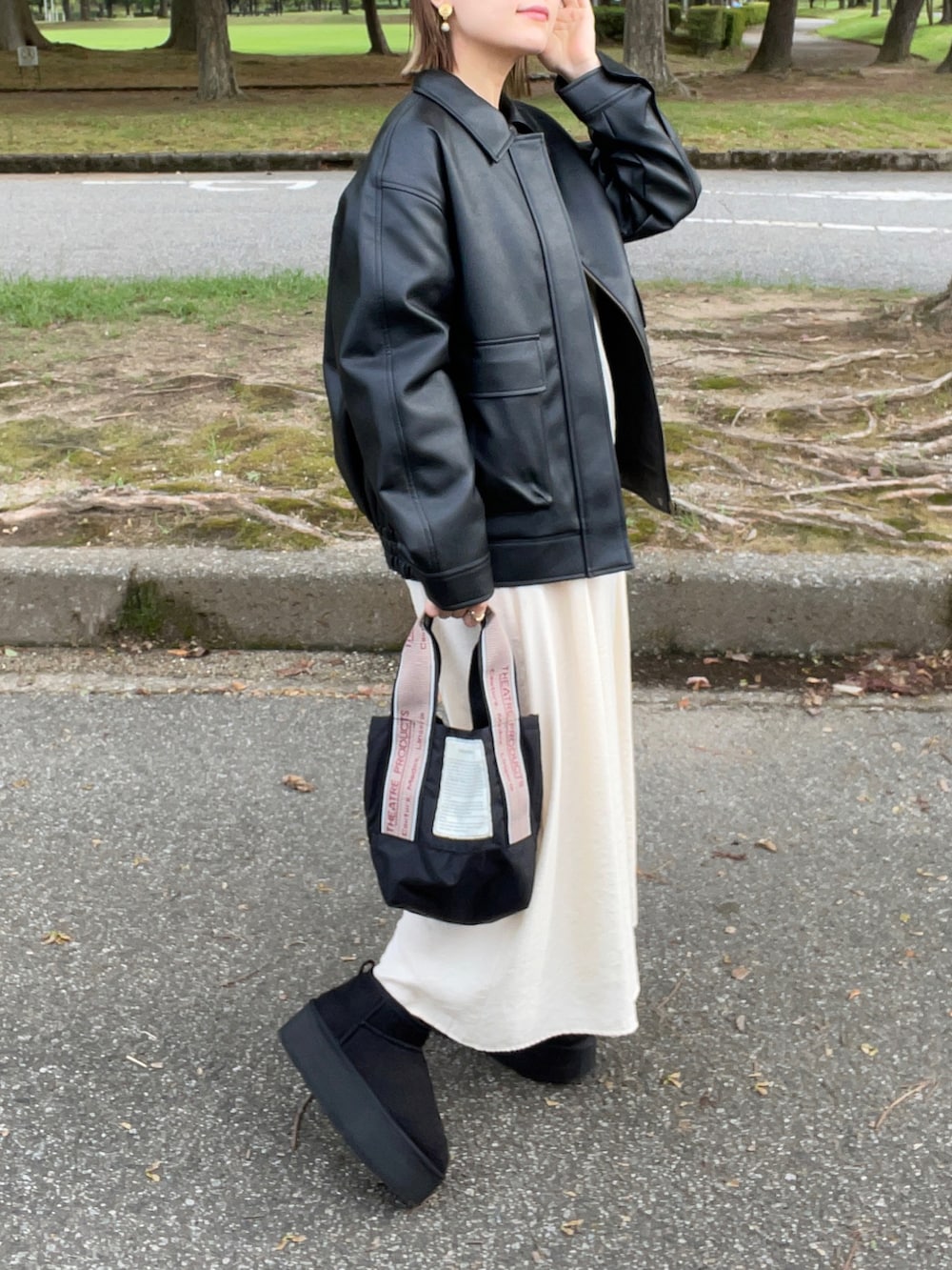 ブラック系のジャケット/アウター、ホワイト系のワンピース、ブラック系のショルダーバッグを着用したレディースの秋コーディネートの3枚目の写真