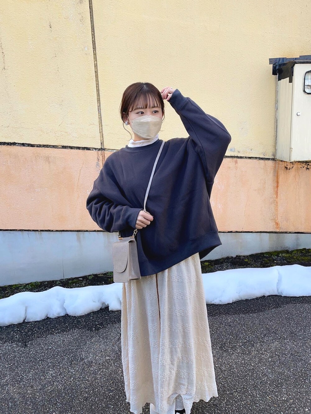 グレー系のスウェット、ホワイト系のTシャツ/カットソー、ベージュ系のスカートを着用したレディースの冬コーディネートの4枚目の写真