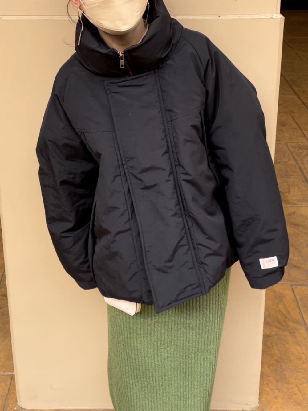 ブラック系のダウンジャケット/コート、グリーン系のスカートを着用したレディースの冬コーディネートの5枚目の写真