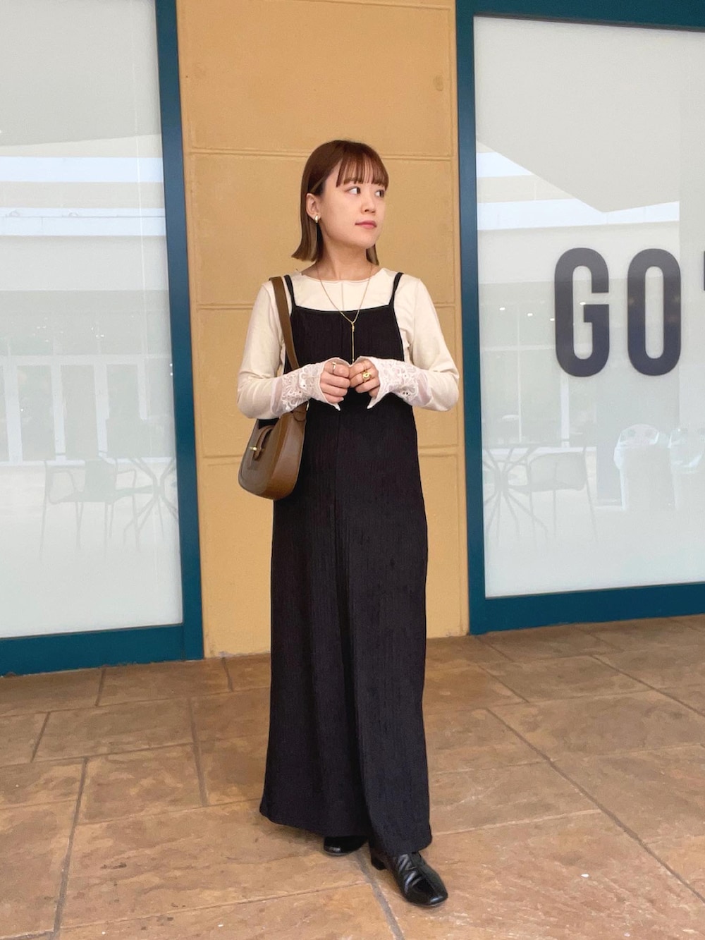 ベージュ系のTシャツ/カットソー、ブラック系のワンピース/ドレス、ブラウン系のバッグを着用したレディースの秋コーディネートの5枚目の写真