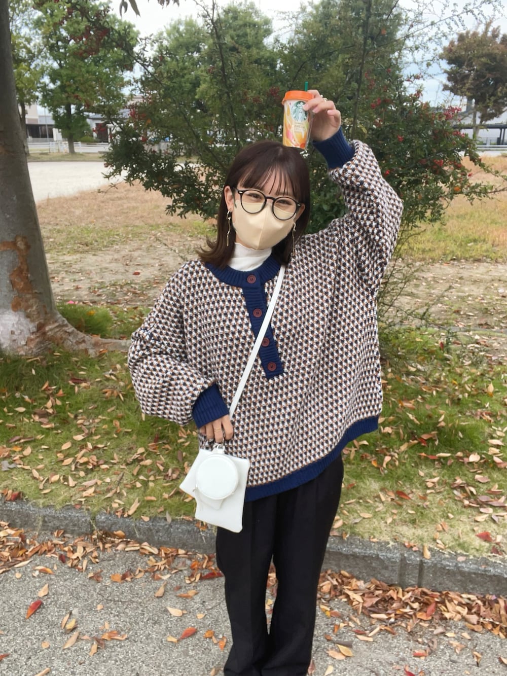 ブルー系のニット/セーター、ホワイト系のTシャツ/カットソー、ホワイト系のショルダーバッグを着用したレディースの秋コーディネートの3枚目の写真