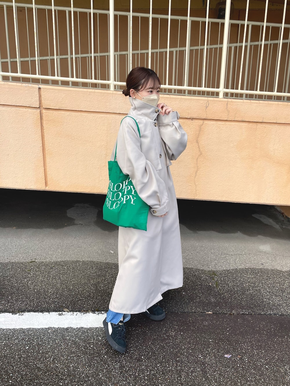 ベージュ系のトレンチコート、ホワイト系のTシャツ/カットソー、ブルー系のデニムパンツを着用したレディースの冬コーディネートの2枚目の写真