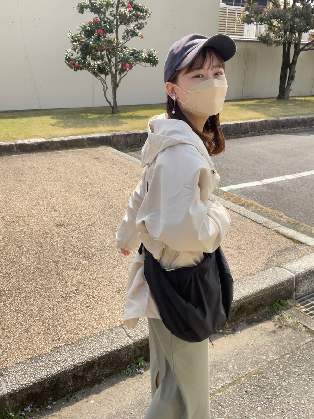 ホワイト系のマウンテンパーカー、グリーン系のワンピース/ドレス、ホワイト系のスニーカーを着用したレディースの春コーディネートの3枚目の写真