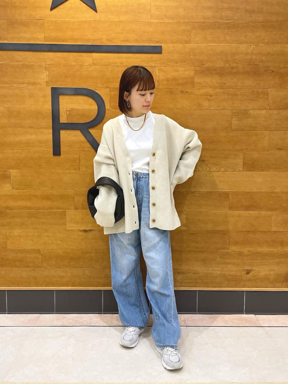 ホワイト系のカーディガン/ボレロ、ホワイト系のTシャツ/カットソー、ブルー系のデニムパンツを着用したレディースの秋コーディネートの4枚目の写真