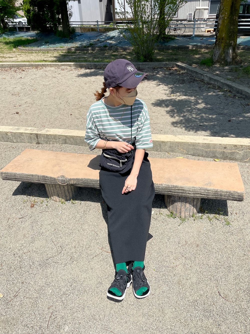 グリーン系のTシャツ/カットソー、ブラック系のスカート、ブラック系のショルダーバッグを着用したレディースの夏コーディネートの3枚目の写真