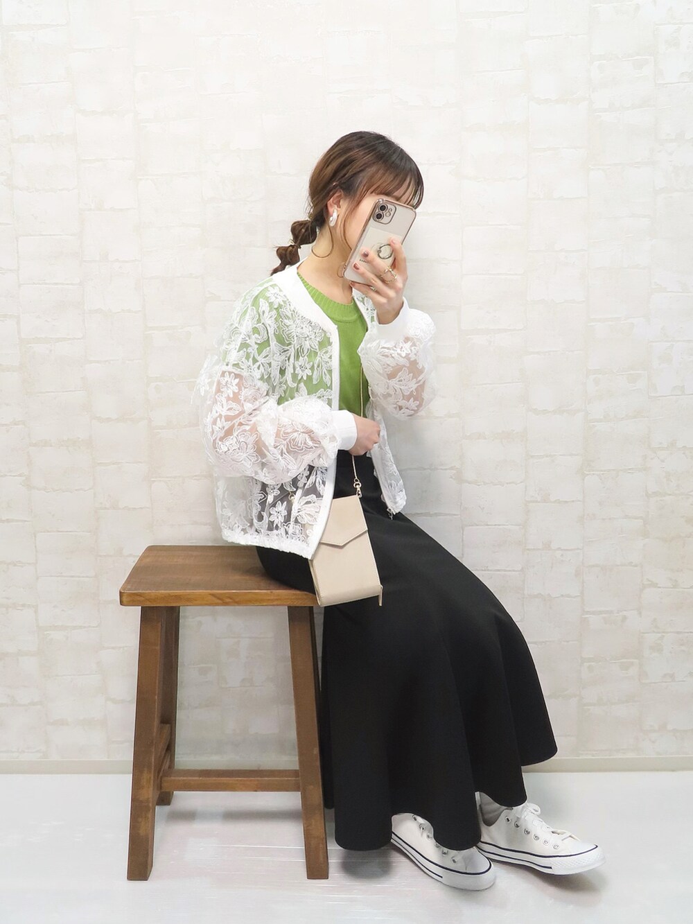 ホワイト系のブルゾン、グリーン系のTシャツ/カットソー、ブラック系のスカートを着用したレディースの春コーディネートの2枚目の写真