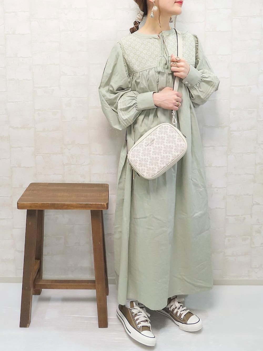 グリーン系のワンピース、ホワイト系のショルダーバッグ、ブラウン系のスニーカーを着用したレディースの春コーディネートの3枚目の写真