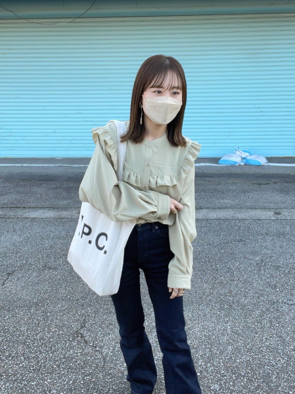 グリーン系のシャツ/ブラウス、ブルー系のデニムパンツ、ホワイト系のトートバッグを着用したレディースの冬コーディネートの2枚目の写真