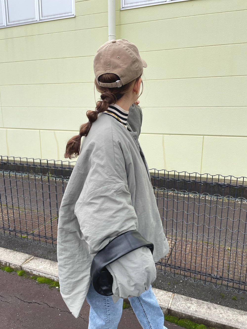 グリーン系のノーカラージャケット、ホワイト系のトップス、ブルー系のデニムパンツを着用したレディースの冬コーディネートの3枚目の写真