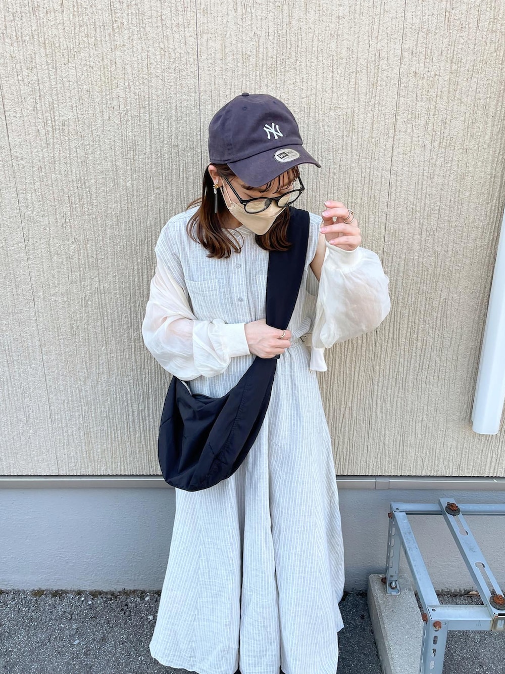 グレー系のシャツ/ブラウス、グレー系のスカート、ブラック系のショルダーバッグを着用したレディースの春コーディネートの3枚目の写真