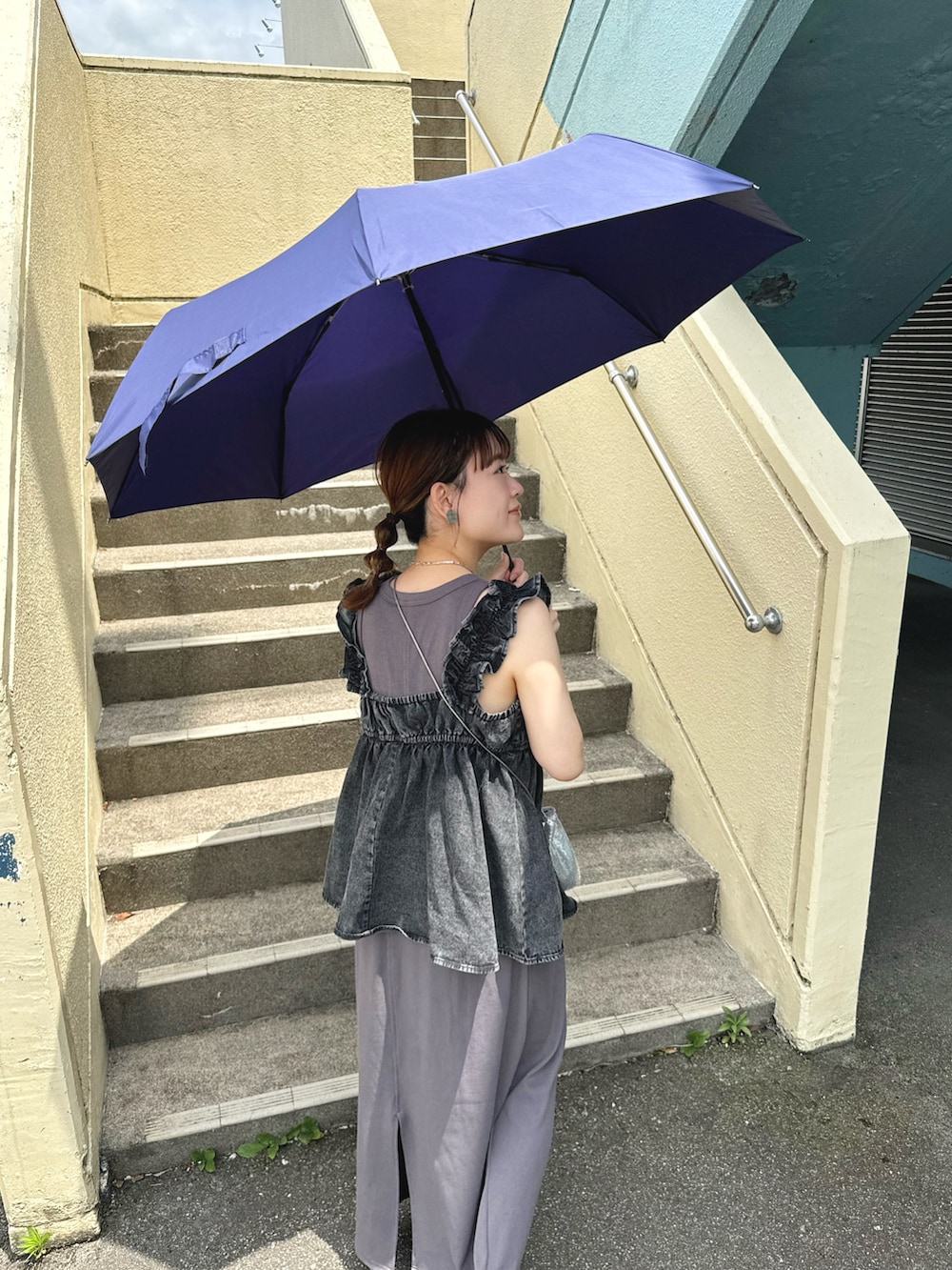 ブラック系のトップス、グレー系のワンピース/ドレス、シルバー系のバッグを着用したレディースの夏コーディネートの2枚目の写真