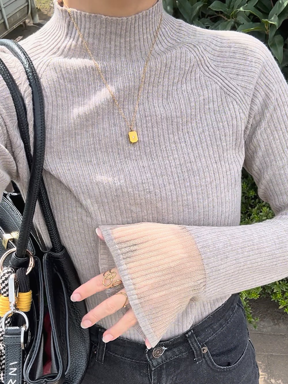 ブラウン系のニット/セーター、ブラック系のワンピース/ドレス、ブラック系のバッグを着用したレディースの秋コーディネートの3枚目の写真