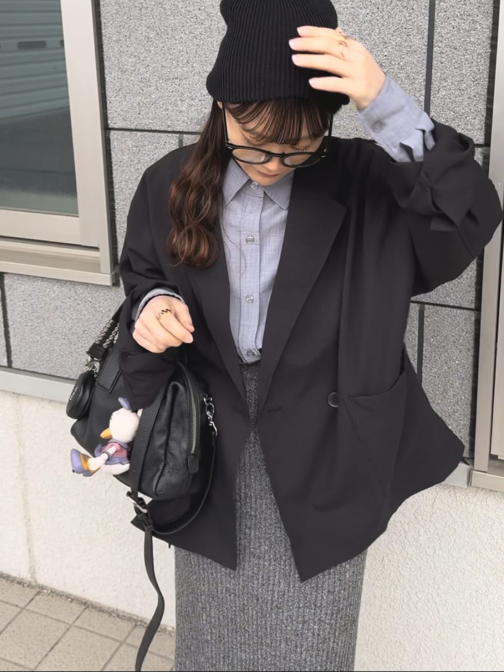 ブラック系のボストンバッグ、ブラック系のテーラードジャケット、ベージュ系のスニーカーを着用したレディースの春コーディネートの2枚目の写真