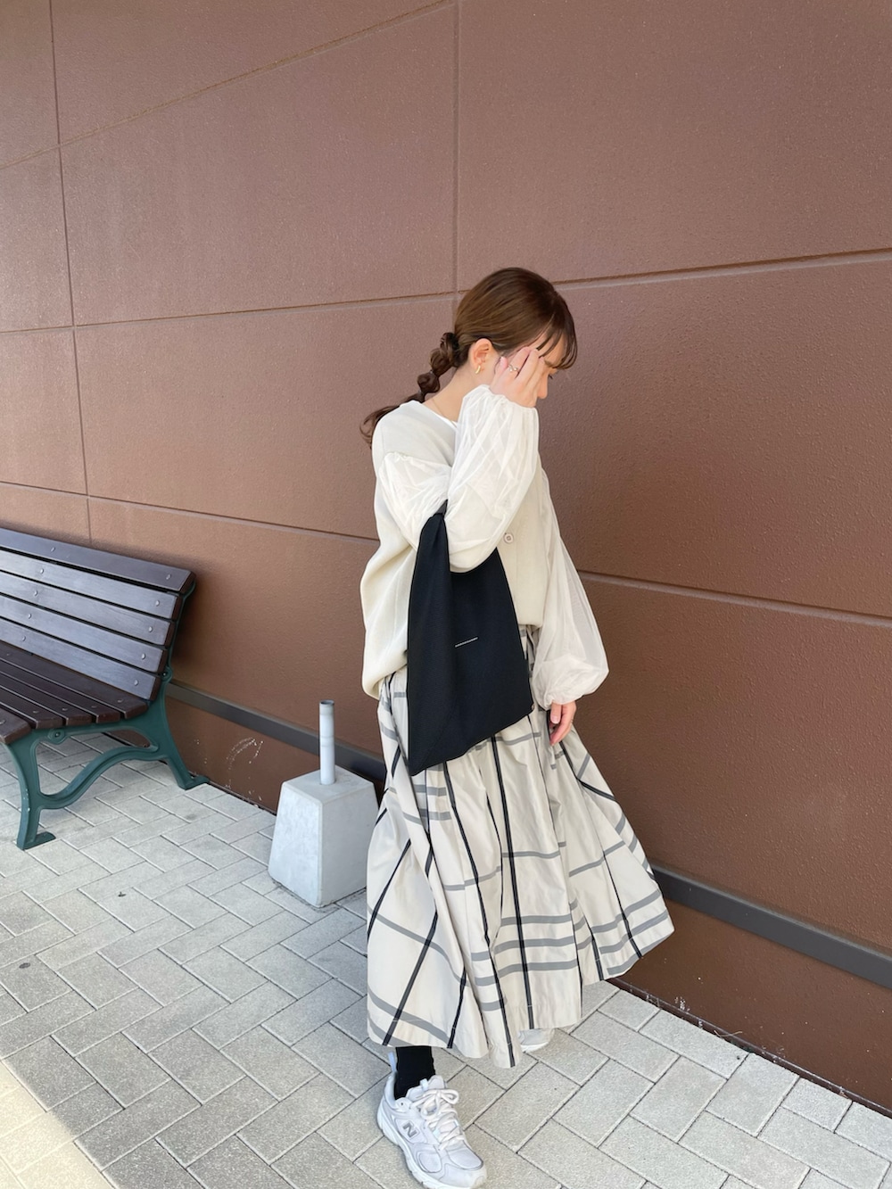 ベージュ系のスカート、ベージュ系のカーディガン/ボレロ、ブラック系のトートバッグを着用したレディースの春コーディネートの2枚目の写真