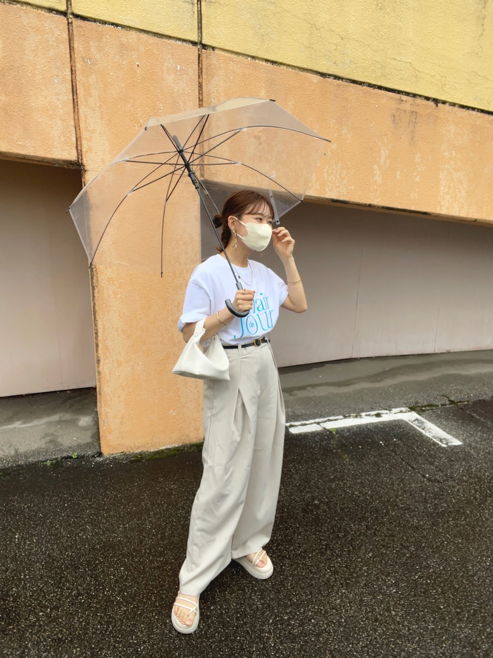 ホワイト系のTシャツ/カットソー、ホワイト系のスラックス、ホワイト系のハンドバッグを着用したレディースの夏コーディネートの4枚目の写真