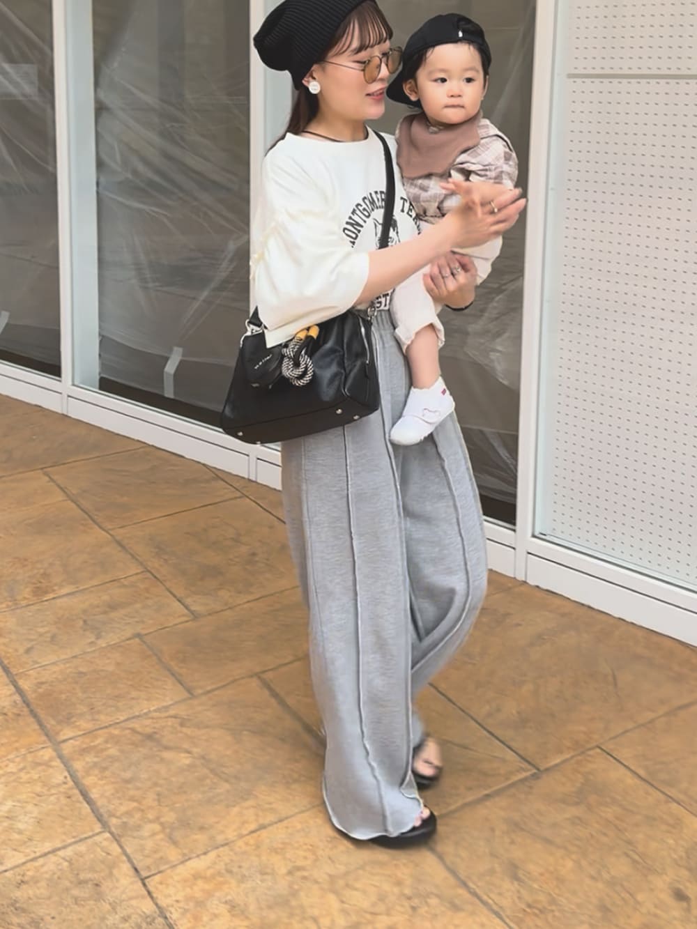 ホワイト系のTシャツ/カットソー、グレー系のスウェットパンツ、ブラック系のボストンバッグを着用したレディースの夏コーディネートの2枚目の写真