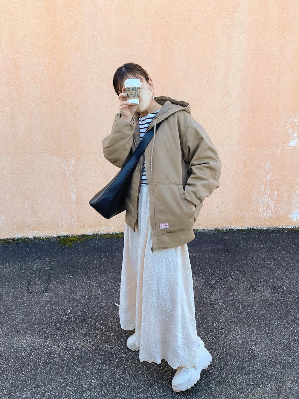 ベージュ系のブルゾン、ホワイト系のTシャツ/カットソー、ベージュ系のスカートを着用したレディースの春コーディネートの3枚目の写真