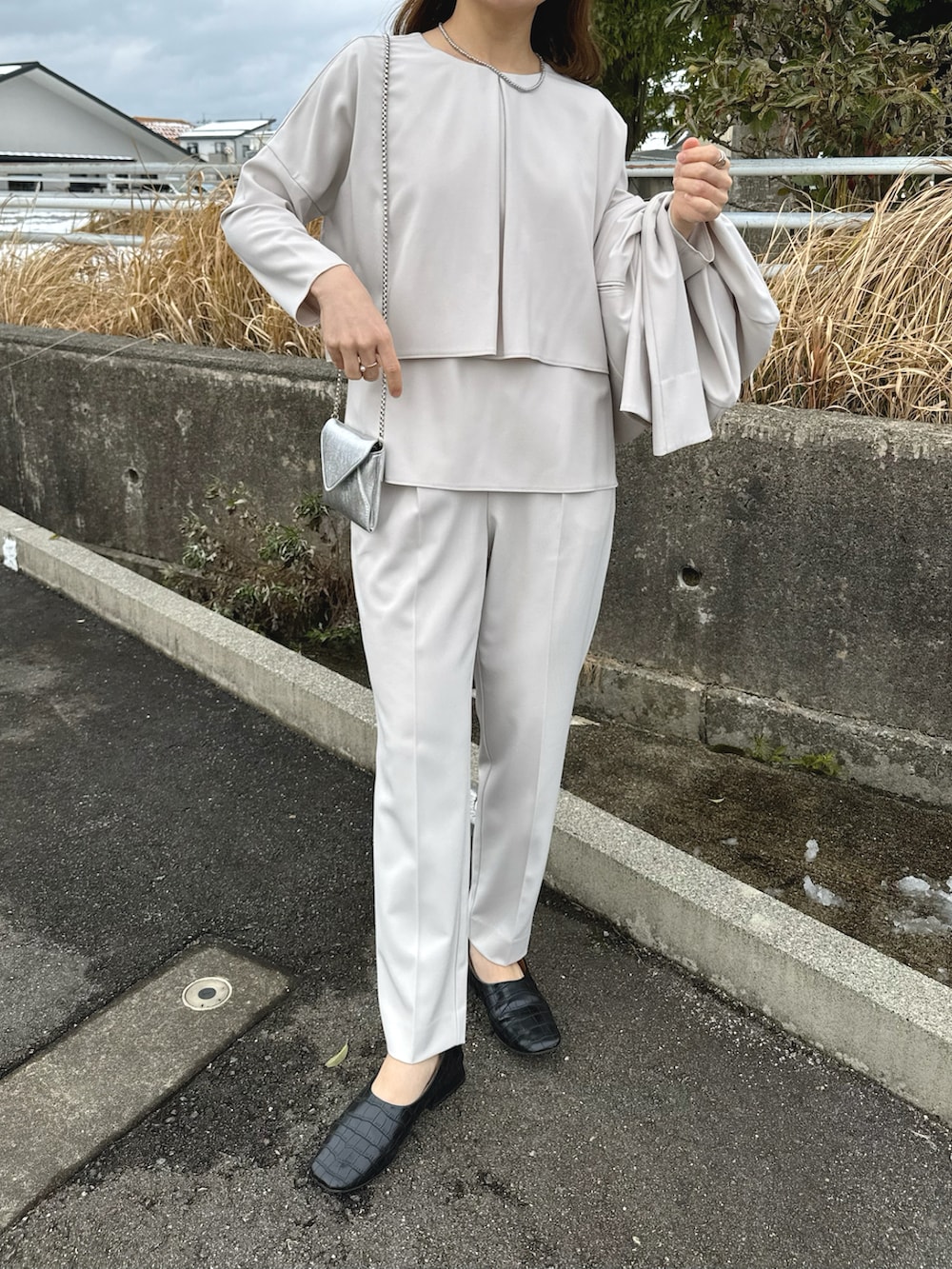 ベージュ系のセットアップ、ブラック系のパンプス、ベージュ系のパンツドレスを着用したレディースの冬コーディネートの4枚目の写真
