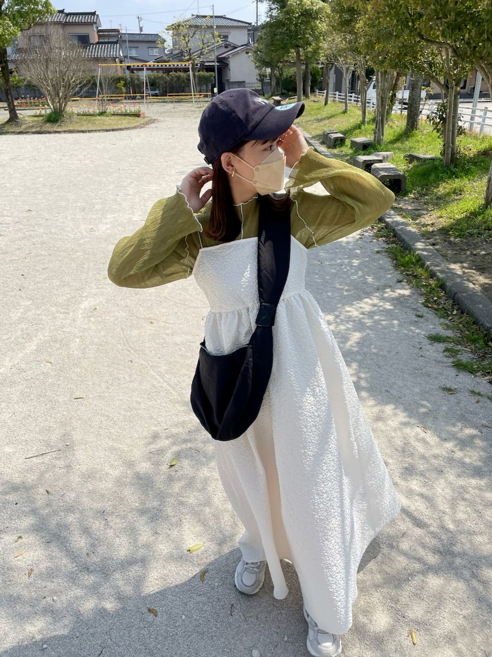 ホワイト系のワンピース、グリーン系のTシャツ/カットソー、ブラック系のショルダーバッグを着用したレディースの春コーディネートの3枚目の写真