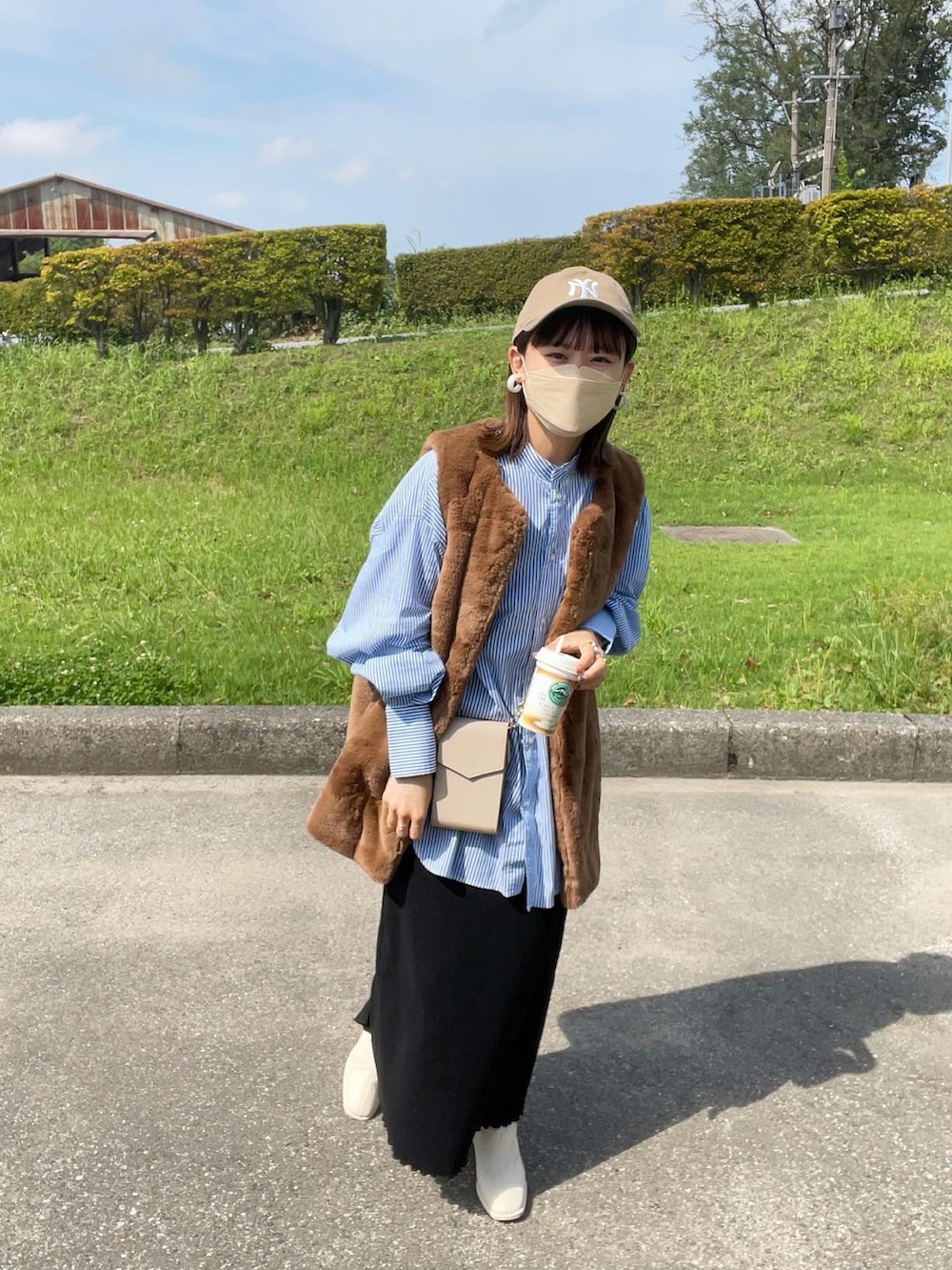 ホワイト系のブーツ、ブルー系のシャツ/ブラウス、ブラウン系のベストを着用したレディースの秋コーディネートの4枚目の写真