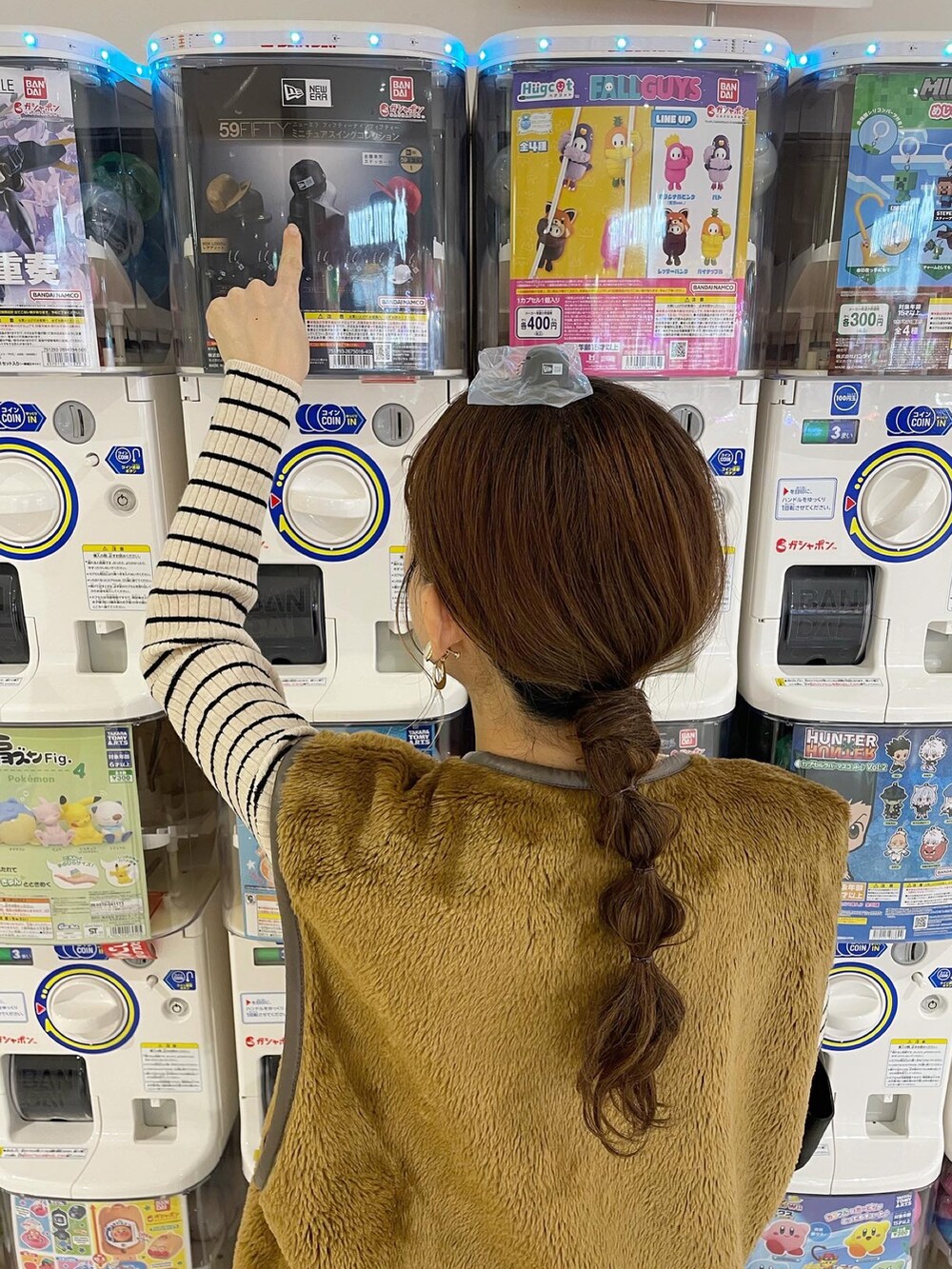 ブラウン系のベスト、ホワイト系のニット/セーター、ブラック系のパンツを着用したレディースの秋コーディネートの5枚目の写真