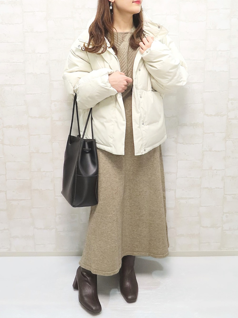 ベージュ系のダウンジャケット/コート、ベージュ系のワンピース、ブラウン系のブーツを着用したレディースの冬コーディネートの4枚目の写真