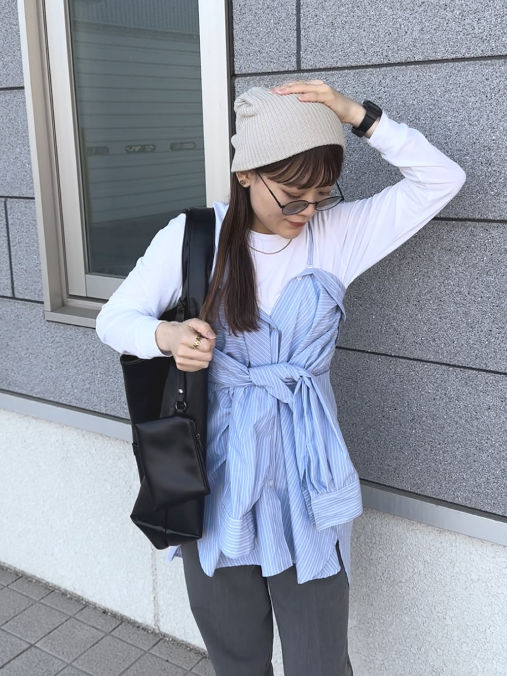 ベージュ系のスニーカー、ブルー系のシャツ/ブラウス、グレー系のパンツを着用したレディースの春コーディネートの2枚目の写真