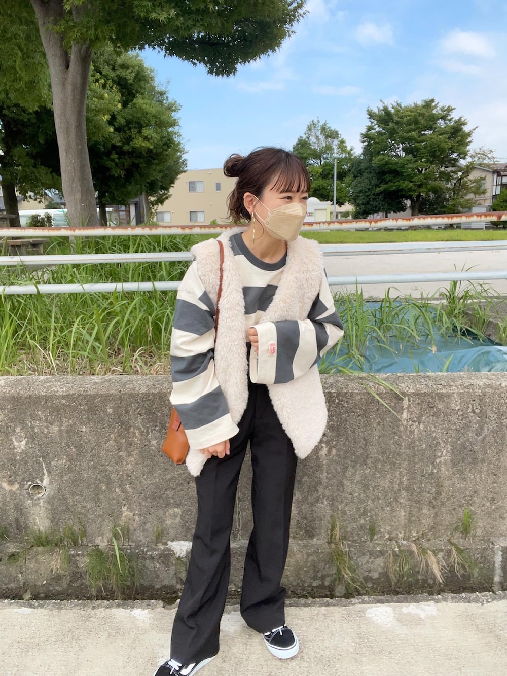 グリーン系のTシャツ/カットソー、グレー系のベスト、ブラック系のスラックスを着用したレディースの秋コーディネートの4枚目の写真