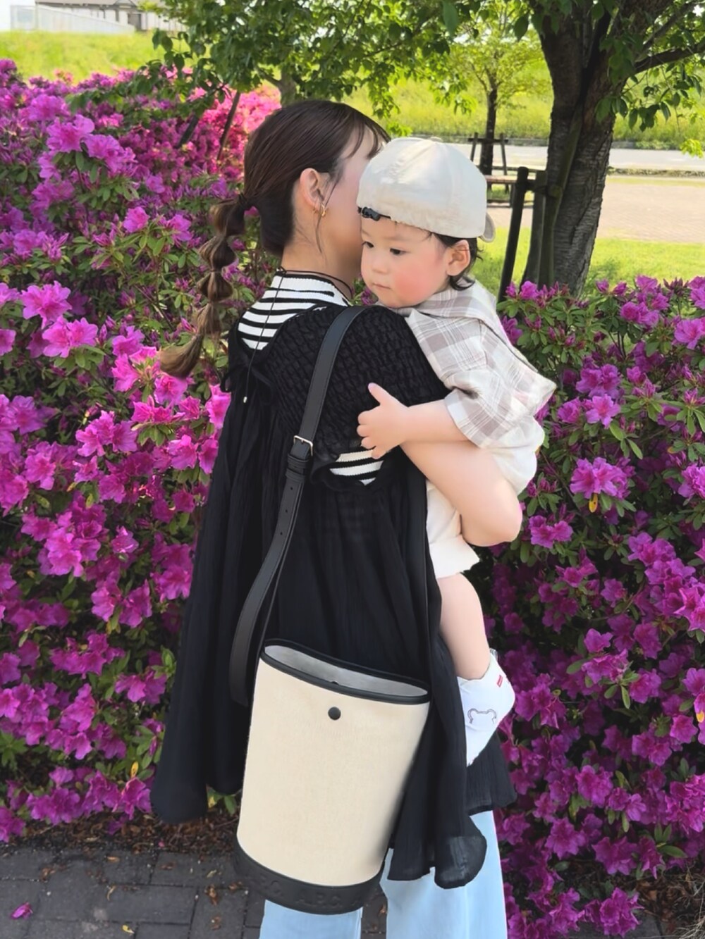 ブラック系のトップス、ホワイト系のタンクトップ、ブラック系のショルダーバッグを着用したレディースの夏コーディネートの2枚目の写真