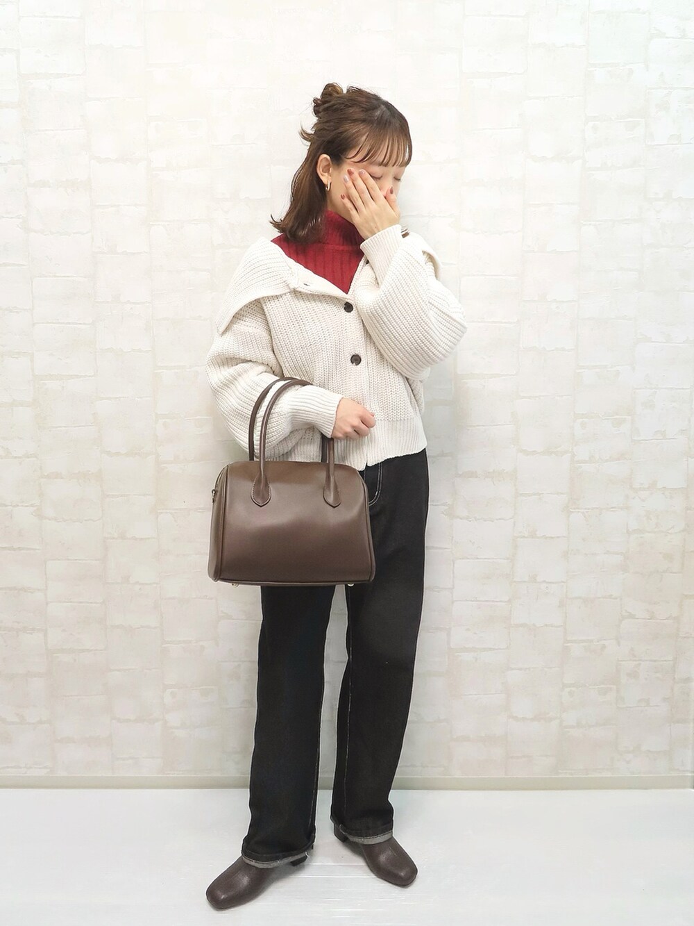 ホワイト系のカーディガン/ボレロ、レッド系のニット/セーター、ブラック系のデニムパンツを着用したレディースの冬コーディネートの3枚目の写真