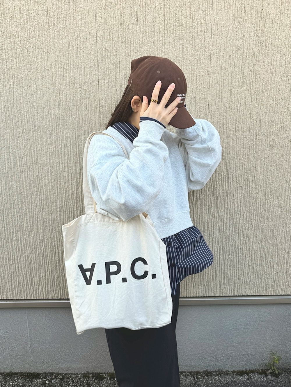 ブルー系のシャツ/ブラウス、ブラック系のスカート、ベージュ系のスニーカーを着用したレディースの春コーディネートの5枚目の写真