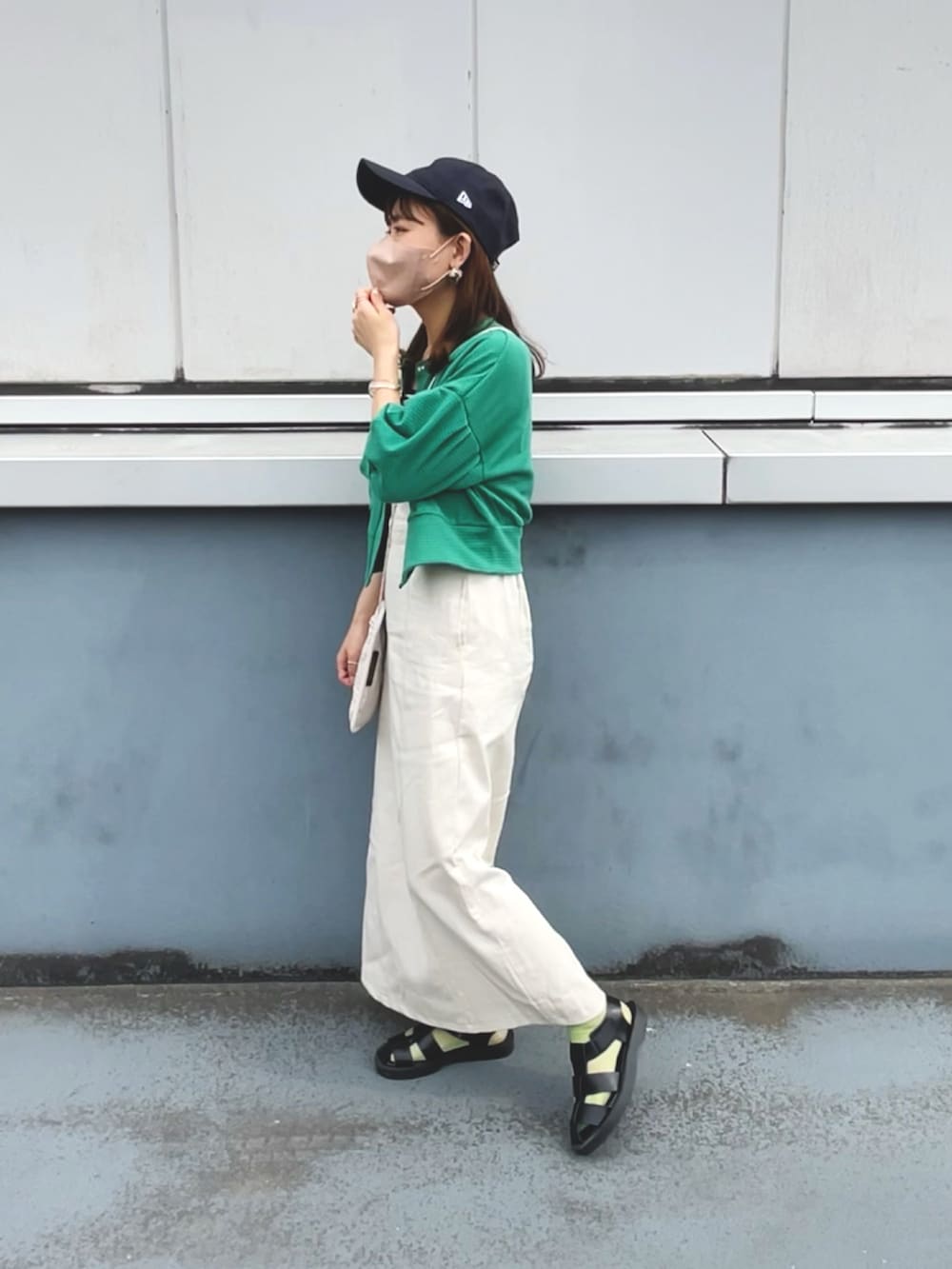 グリーン系のカーディガン/ボレロ、ホワイト系のワンピース、ブラック系のキャミソールを着用したレディースの夏コーディネートの2枚目の写真