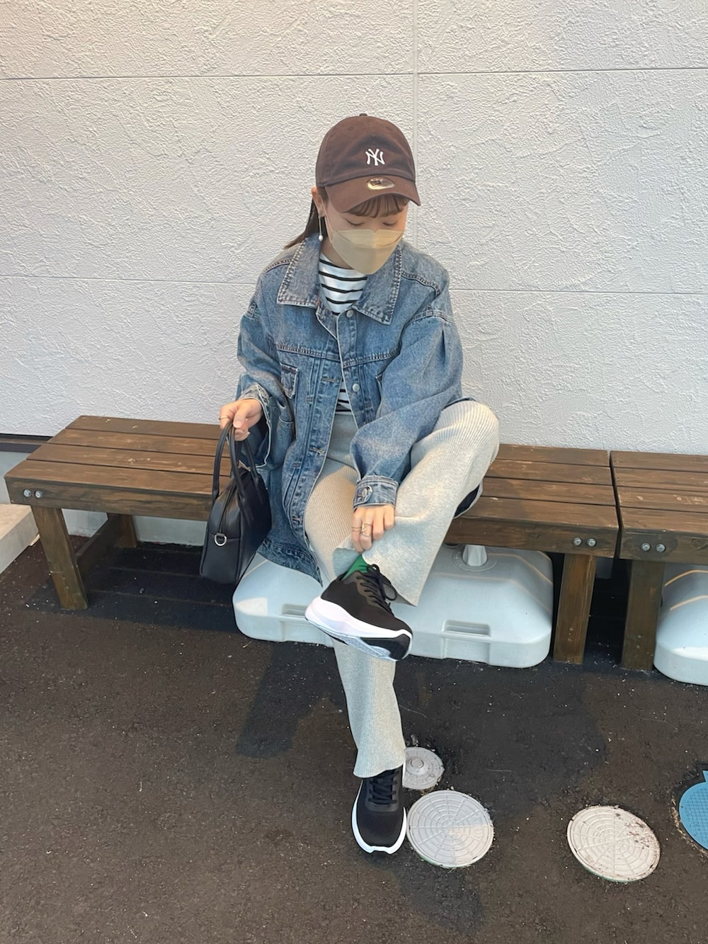 ブルー系のデニムジャケット、グレー系のその他パンツ、ブラック系のスニーカーを着用したレディースの春コーディネートの3枚目の写真