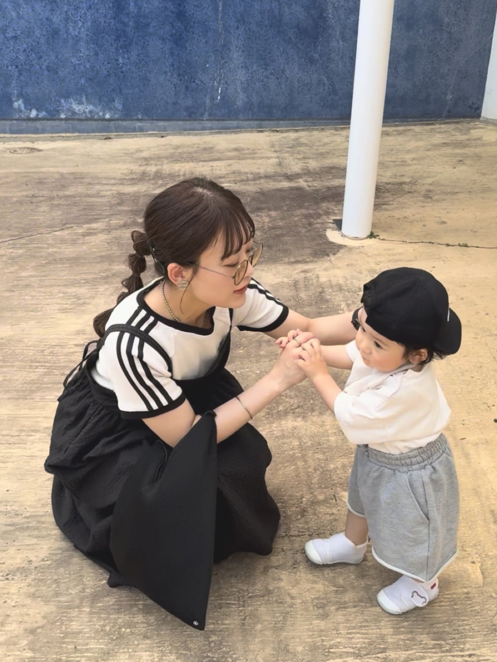 グレー系のセットアップ、ブラック系のワンピース、ブラック系のサンダルを着用したレディースの夏コーディネートの2枚目の写真